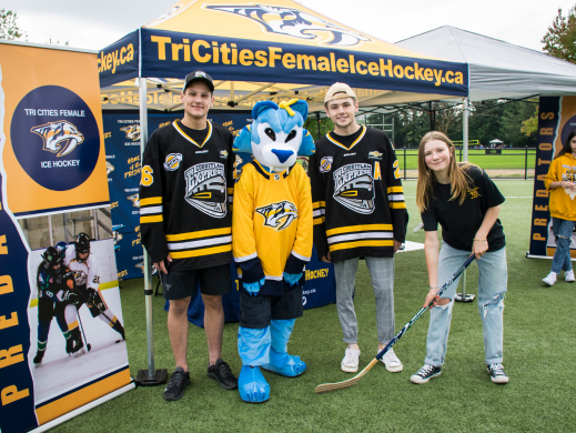 People standing in front of a sport organization's tent