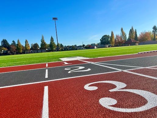 Numbered red running track and green turf field