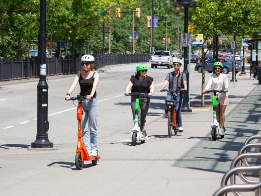 Four e-scooter riders on road
