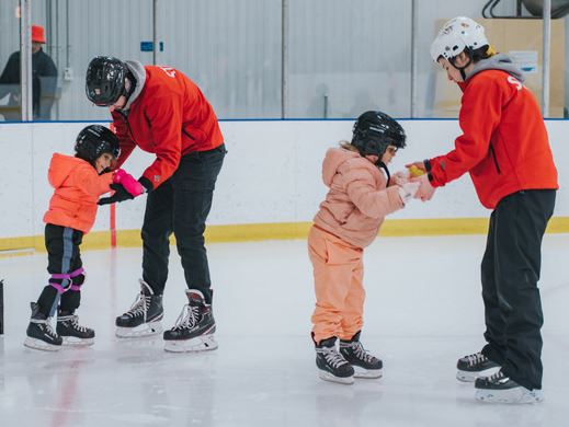 Skating instructors assisting children in skating lessons