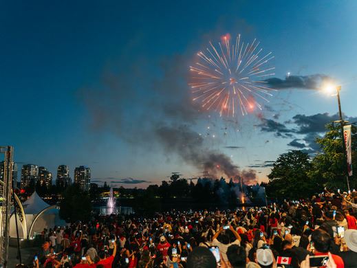 Fireworks over Lafarge Lake with a big crowd watching with dusk sky.