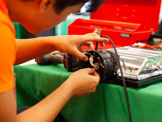 A volunteer works to repair a small item at Coquitlam's Repair Cafe 