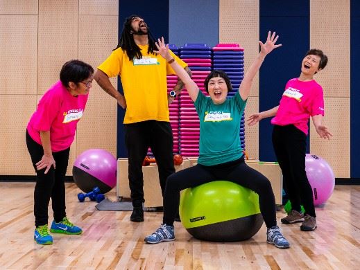 Group of happy people in fitness studio wearing brightly coloured shirts